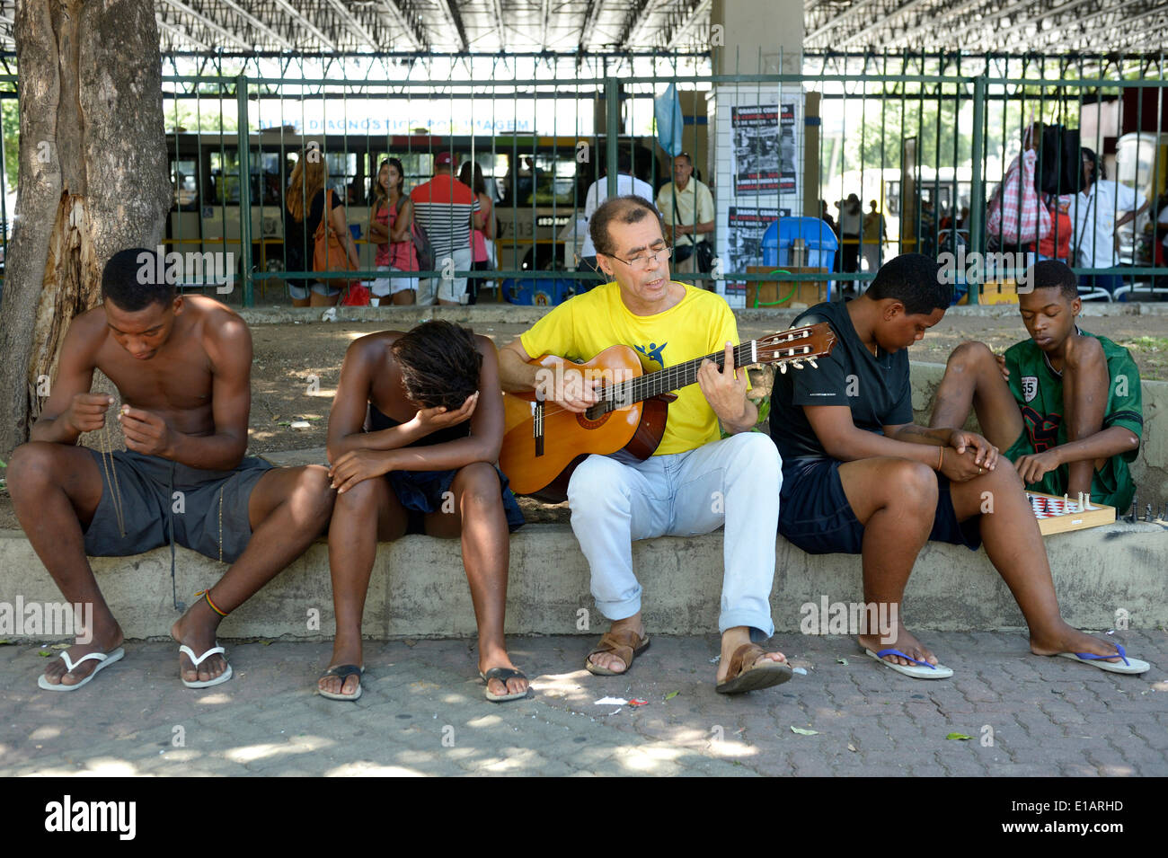 Trabajador Social, músico, dando a los niños de la calle clases de guitarra en la estación de tren Central do Brasil, Rio de Janeiro. Foto de stock