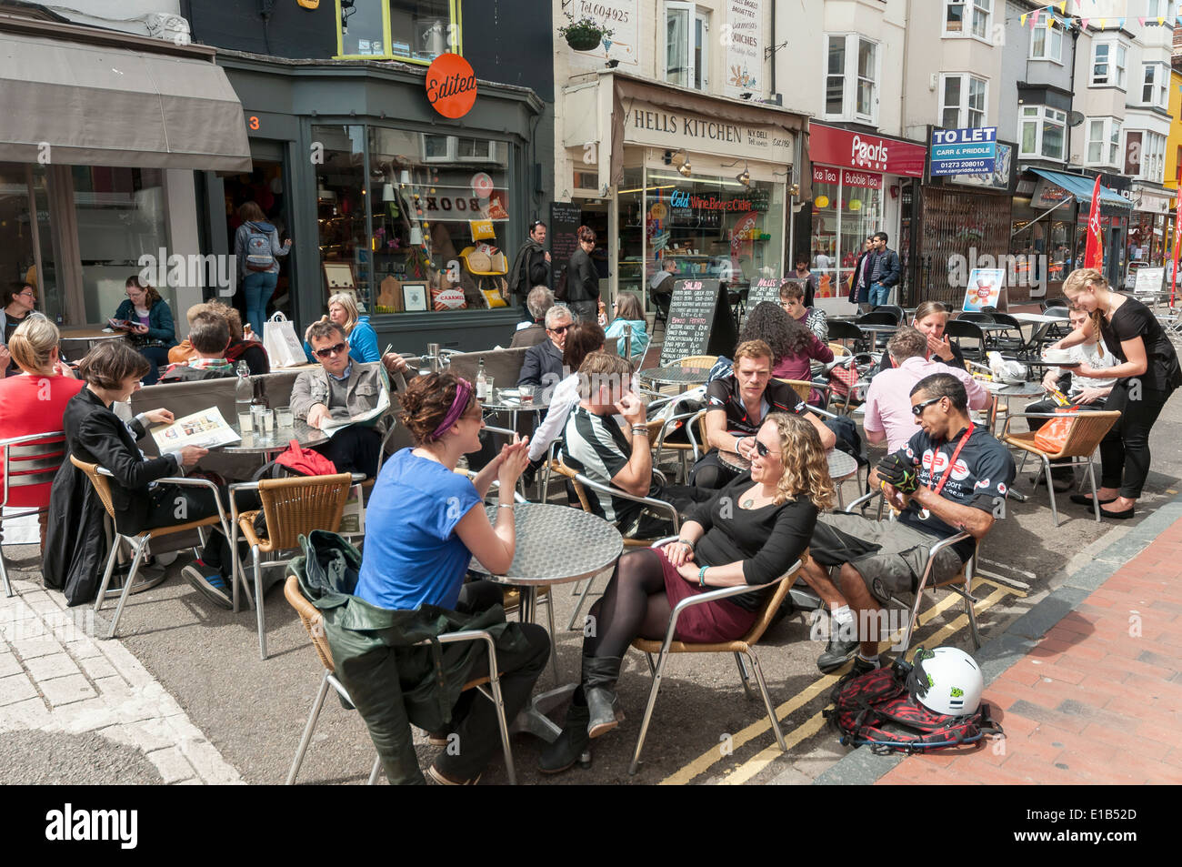 La gente disfruta de la comida y bebidas en pubs y cafés al aire libre en el área de North Laine en Brighton, Inglaterra, Reino Unido. Foto de stock