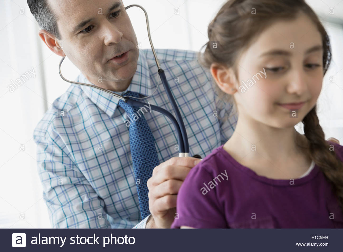 Pediatra comprobación patientÕs respiración con estetoscopio Foto de stock