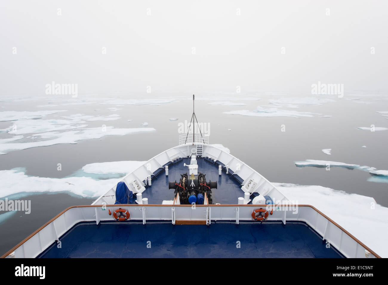 La vista sobre la cubierta de un barco crucero en la región del Ártico canadiense, que se mueve a través de témpanos de hielo. Foto de stock