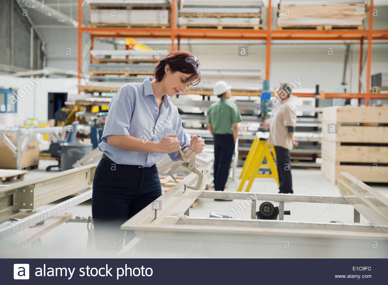 Trabajador por medio de un tornillo de banco agarre en la planta de fabricación de la herramienta Foto de stock