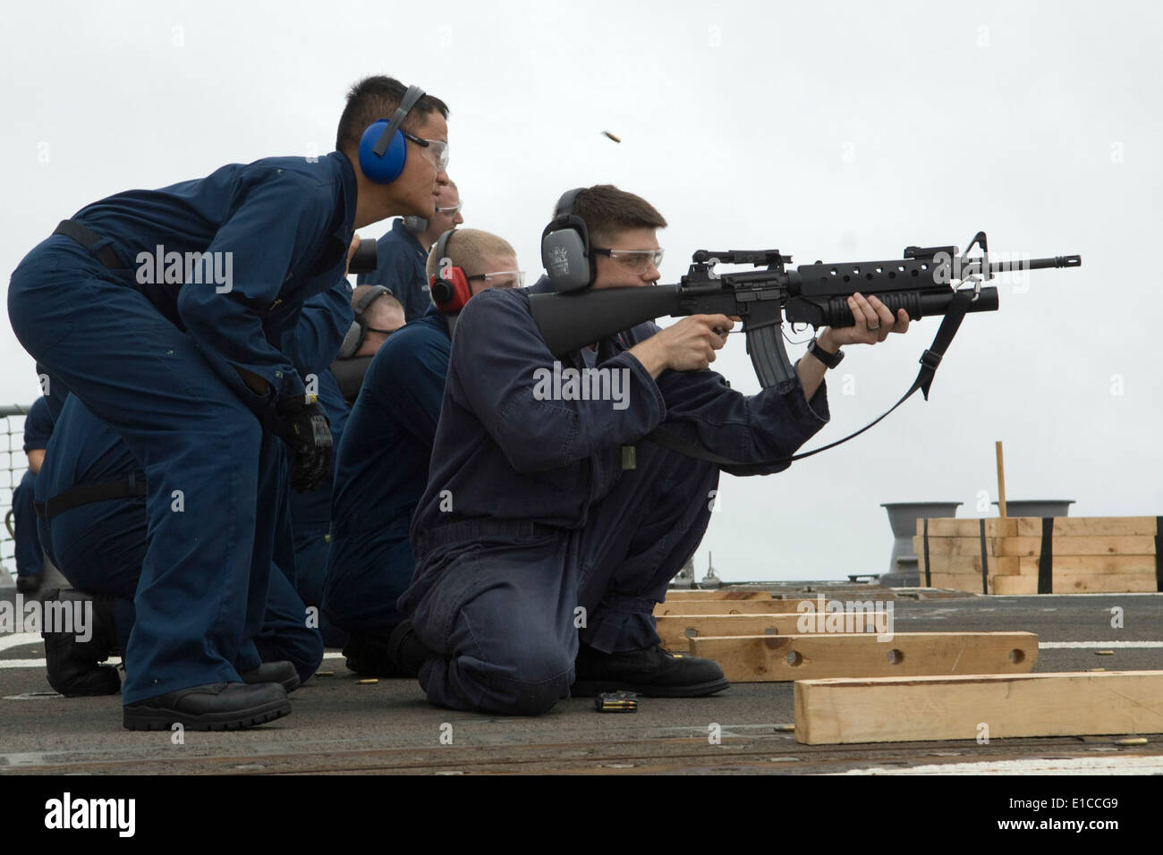 Marina de los EE.UU. 2ª clase Controlman fuego Chaung Pha observa como técnico de casco de segunda clase Briscoe Donipaul desencadena un fusil M-16 d Foto de stock