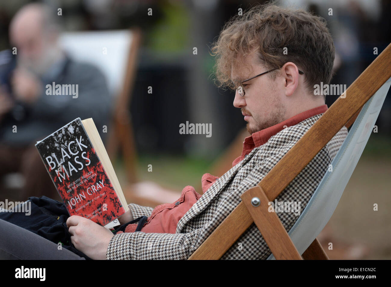 Heno en Wye, Gales, el sábado 31 de mayo de 2014 personas sentadas en sillas leyendo libros sobre el penúltimo día del Daily Telegraph de 2014 Festival de la literatura de heno, Gales, Reino Unido Foto ©Keith morris Foto de stock