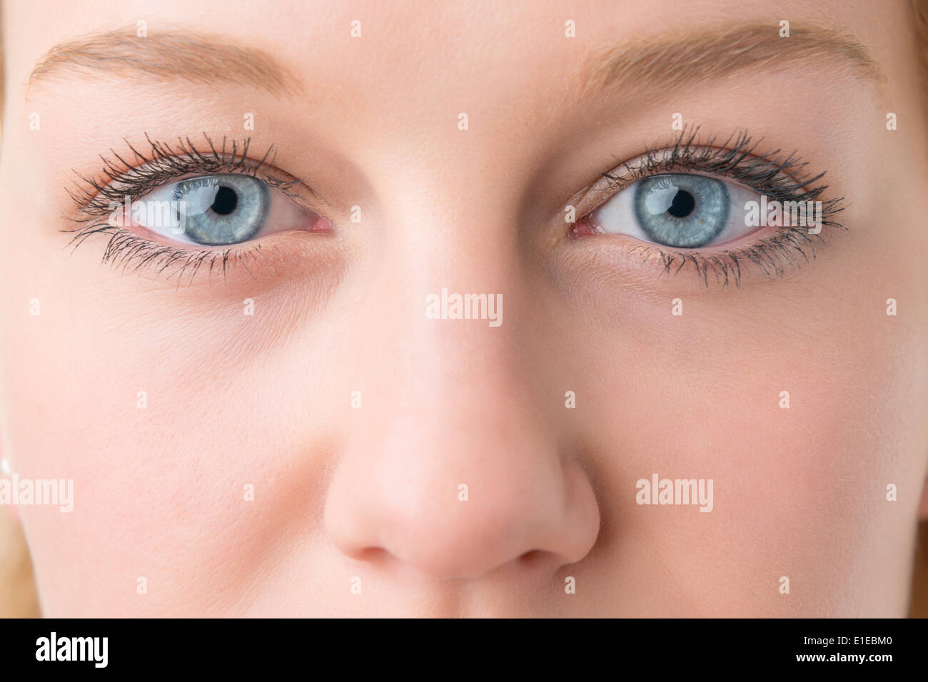 Primer plano de una joven mujer rubia con ojos azules y la nariz Foto de stock