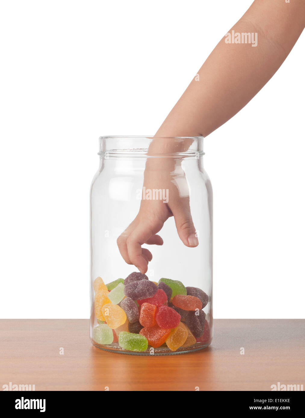 La mano del niño para llegar a tomar dulces de una jarra Foto de stock