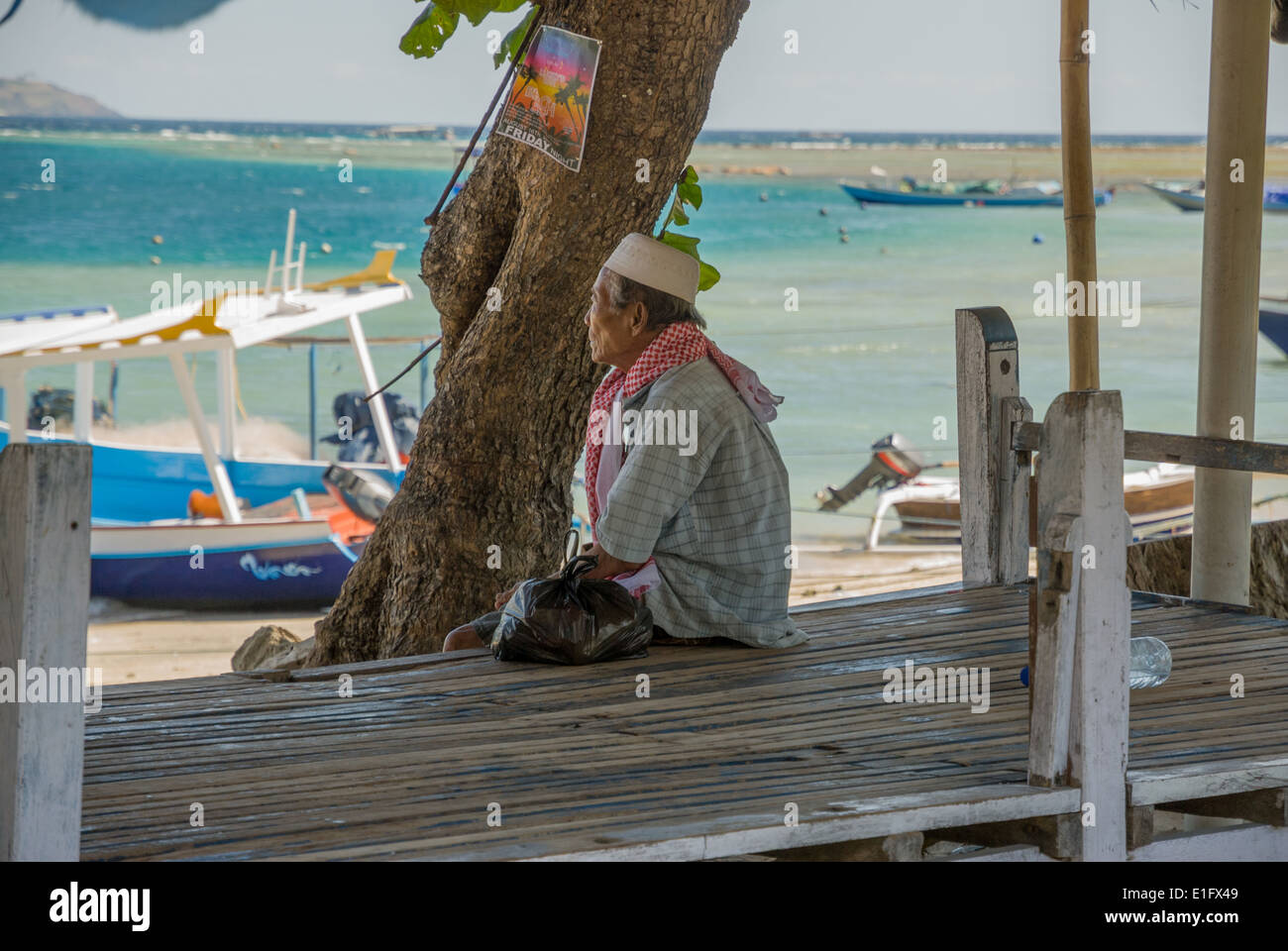 Nusa Lembongan local asiento hombre mirando el mar Indonesia Foto de stock