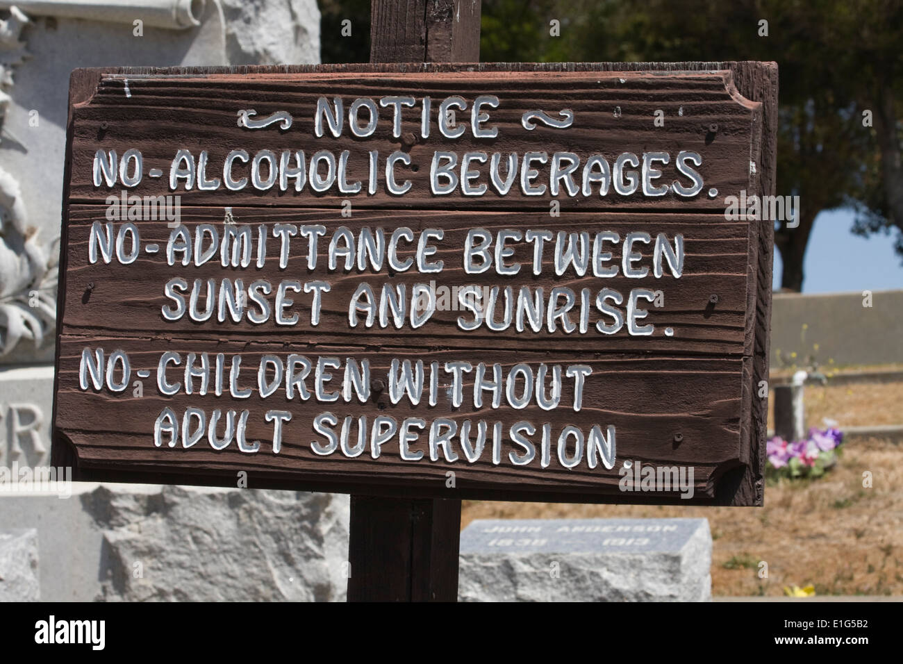 "Nada de Alcohol, admisión o niños". Signo encontrado en un cementerio de San Juan Bautista, California. Foto de stock