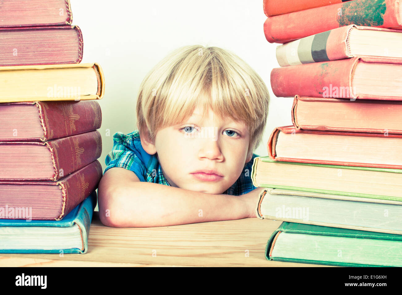 Hartos de la escuela niño rodeado de libros Foto de stock