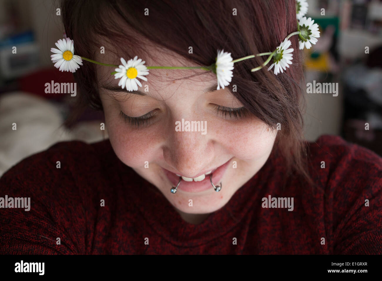 Mujer joven sonriente con una cadena de margarita Foto de stock