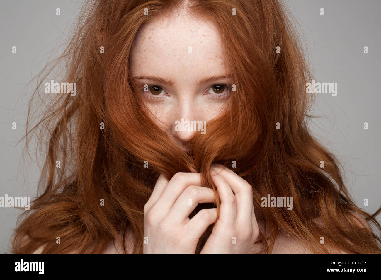 Retrato de mujer joven, las manos en el cabello Foto de stock