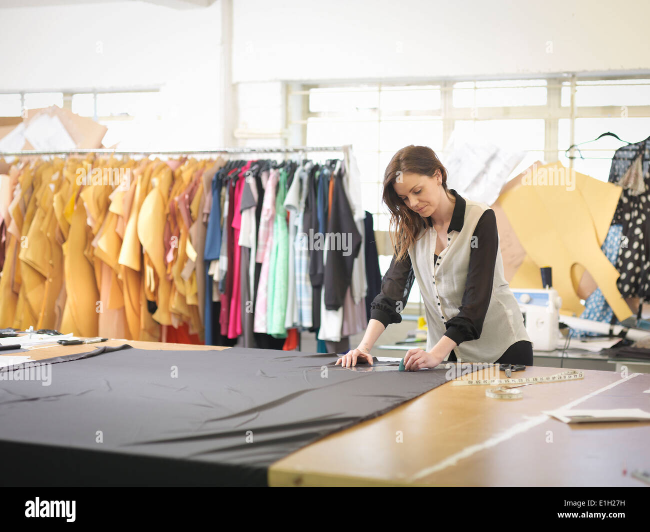 Diseñador de moda medir tejido en fashion design studio Foto de stock