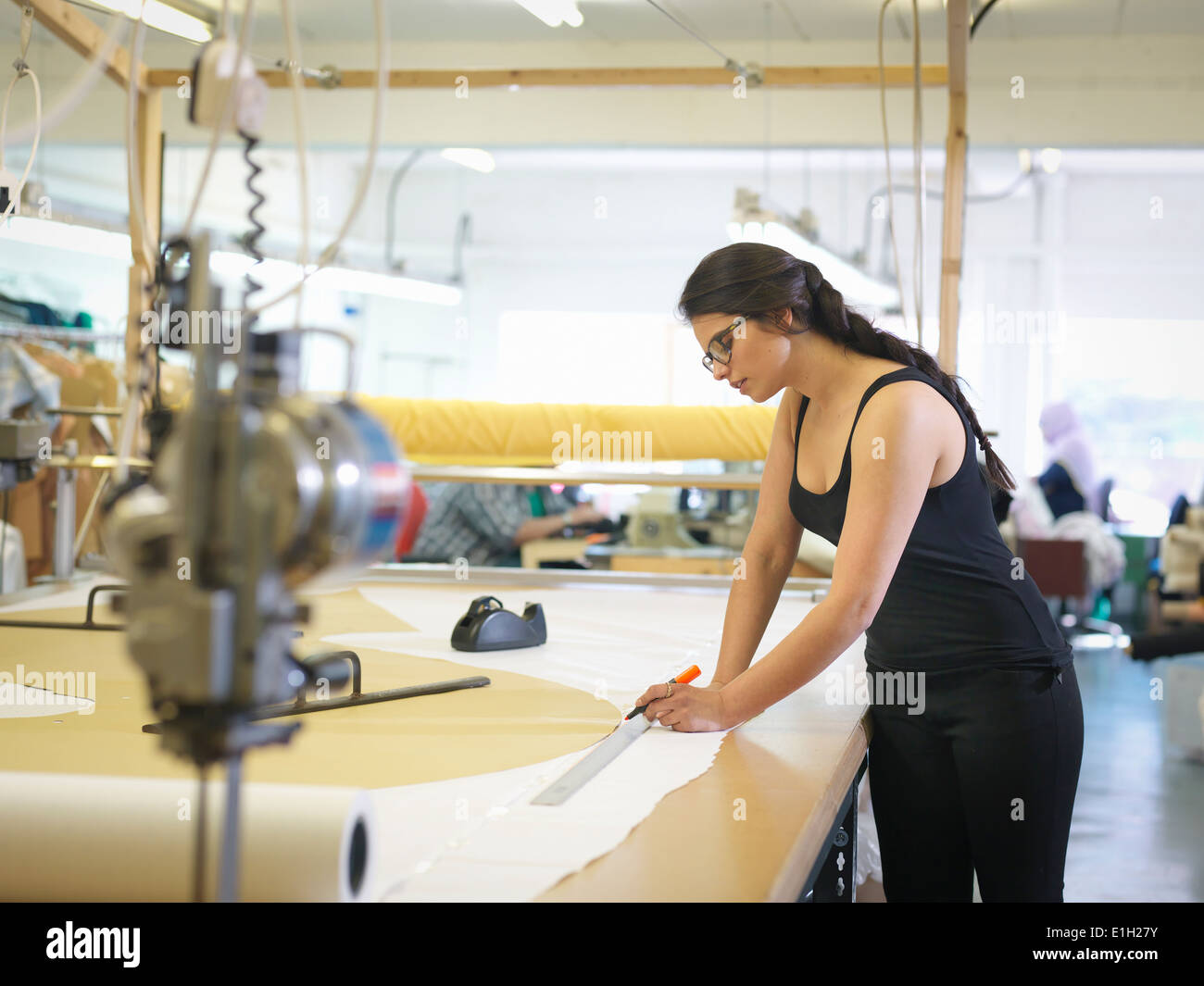 Trabajadora de la confección femenina paño marcado en fábrica de ropa Foto de stock