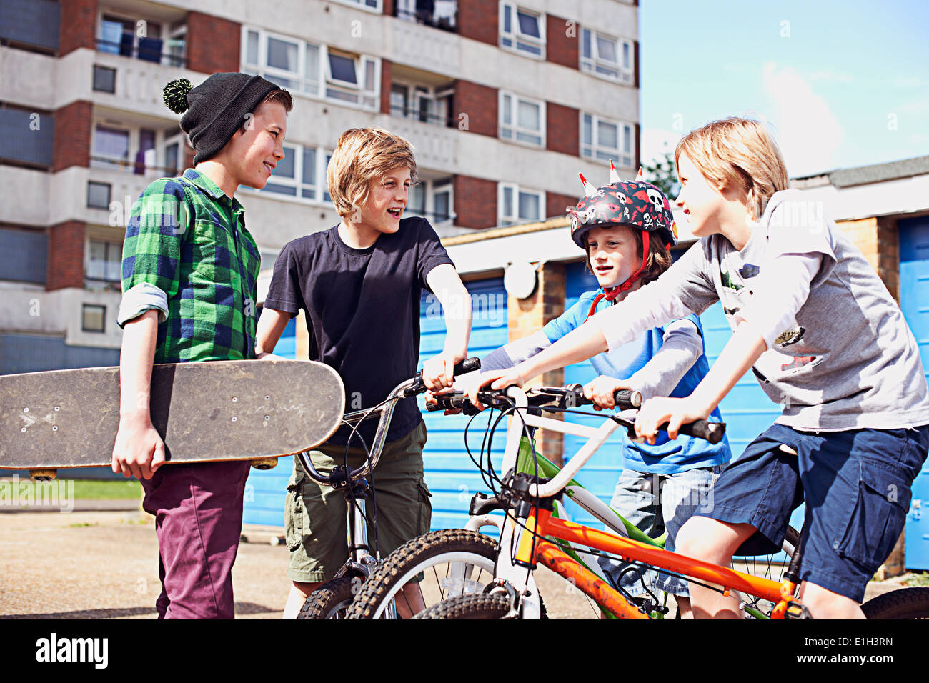 Grupo de muchachos hablando con bicicletas y patinetas Foto de stock