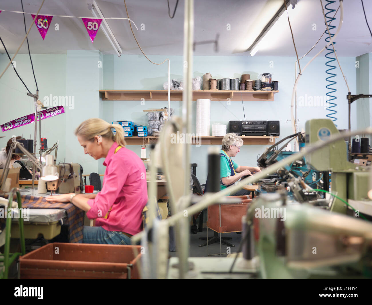 Los trabajadores de la costura en la fábrica de ropa Foto de stock