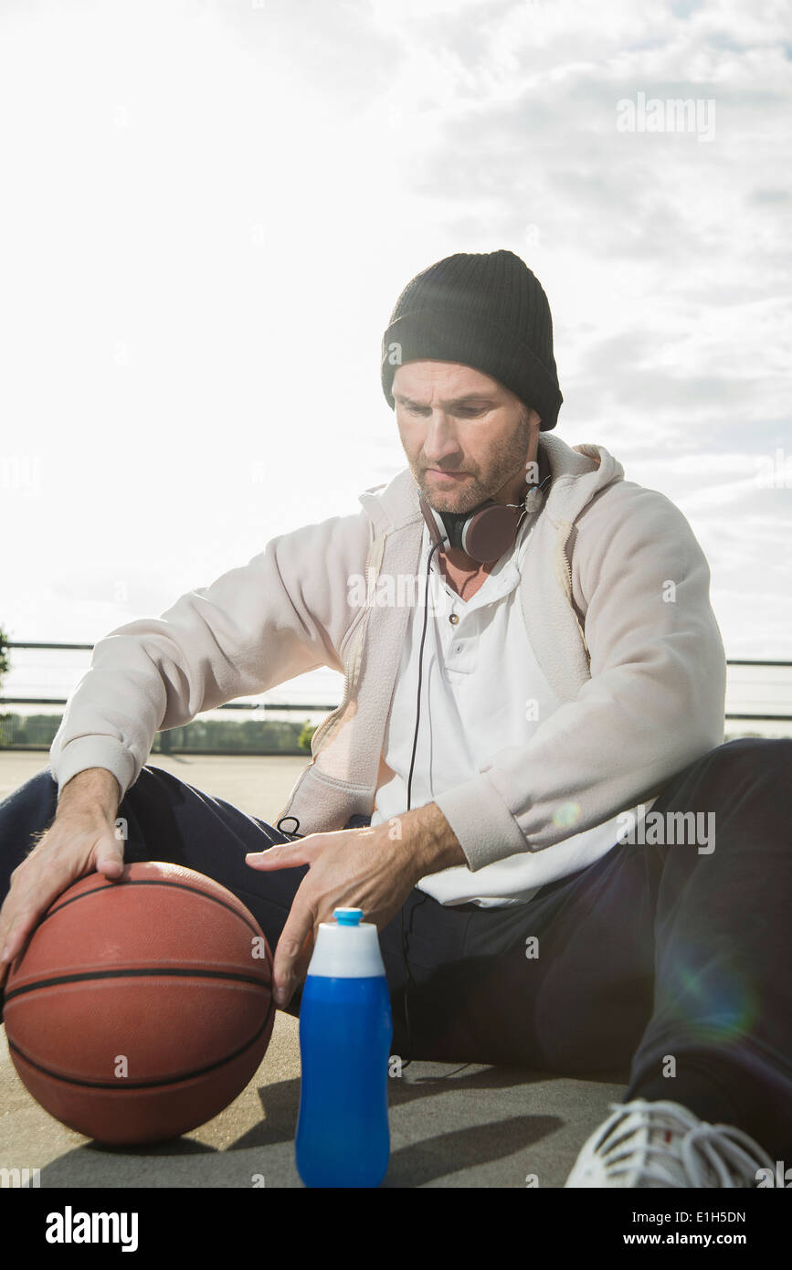 El jugador de baloncesto en el suelo con el baloncesto Foto de stock