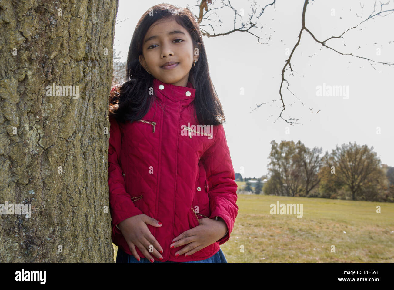 Retrato de muchacha RECOSTADA contra el tronco de árbol Foto de stock