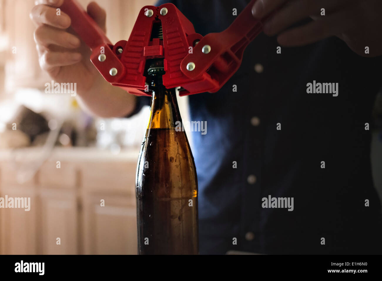 Cerca del hombre usar corona corker para el cierre de la parte superior de la botella de cerveza artesanal inicio Foto de stock