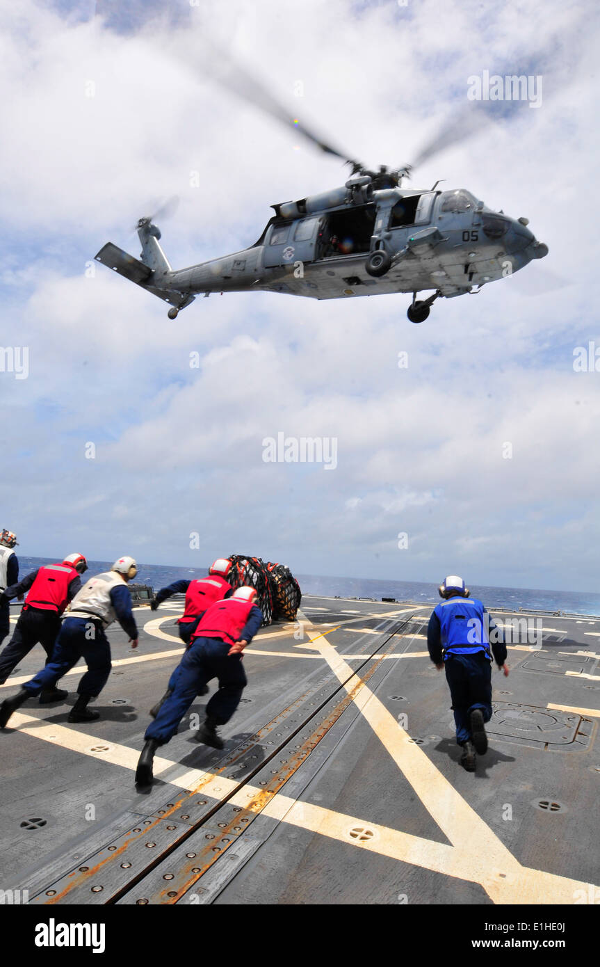 Los marineros de EE.UU. asignados al misil destructor USS McCampbell (DDG 85) ejecutar para recuperar palets de suministros entregados por un Foto de stock