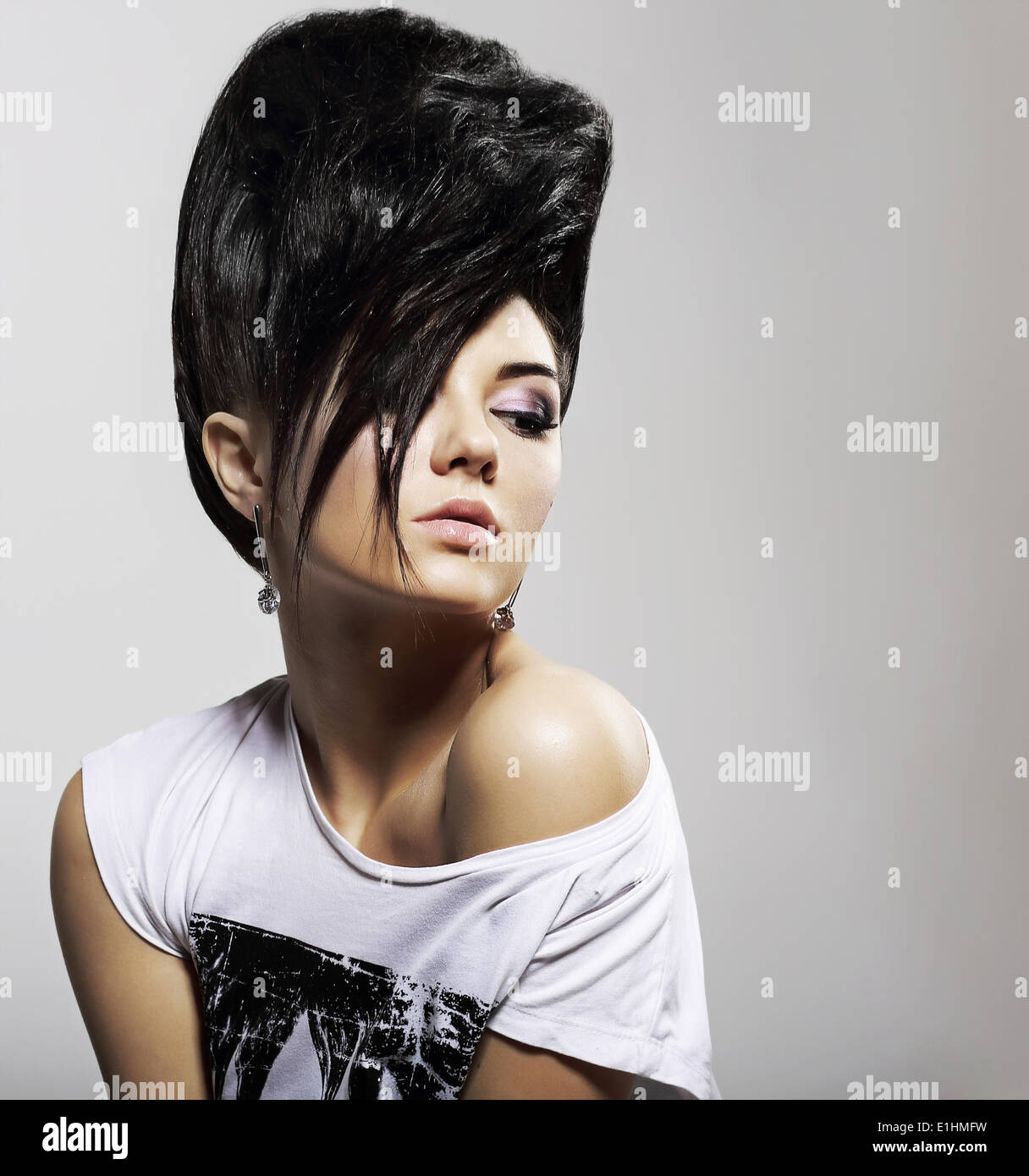 Updo pelo negro. Elegante mujer con peinado de moda con aretes de diamante Foto de stock