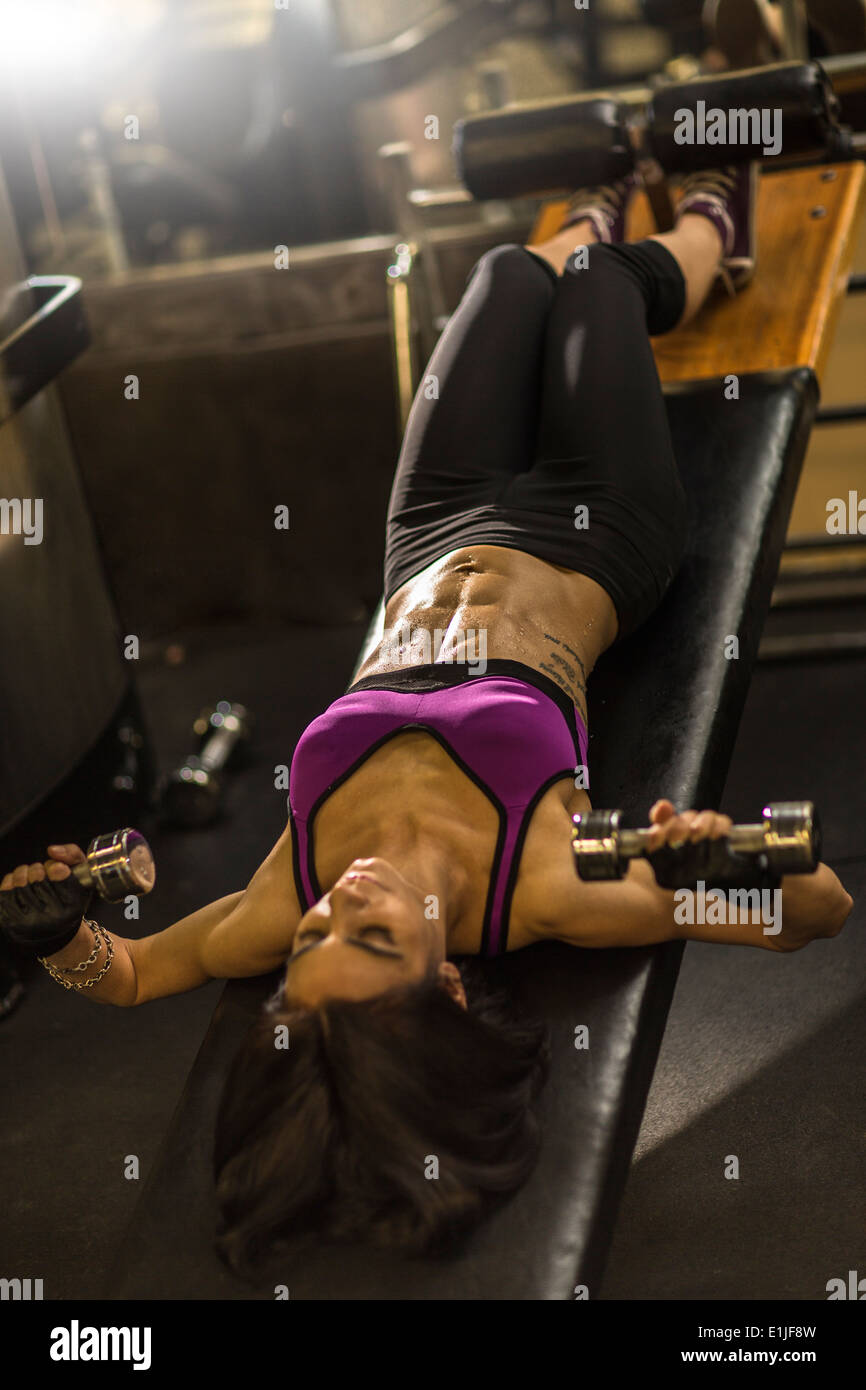 Mitad mujer adulta haciendo ejercicios abdominales en banco de