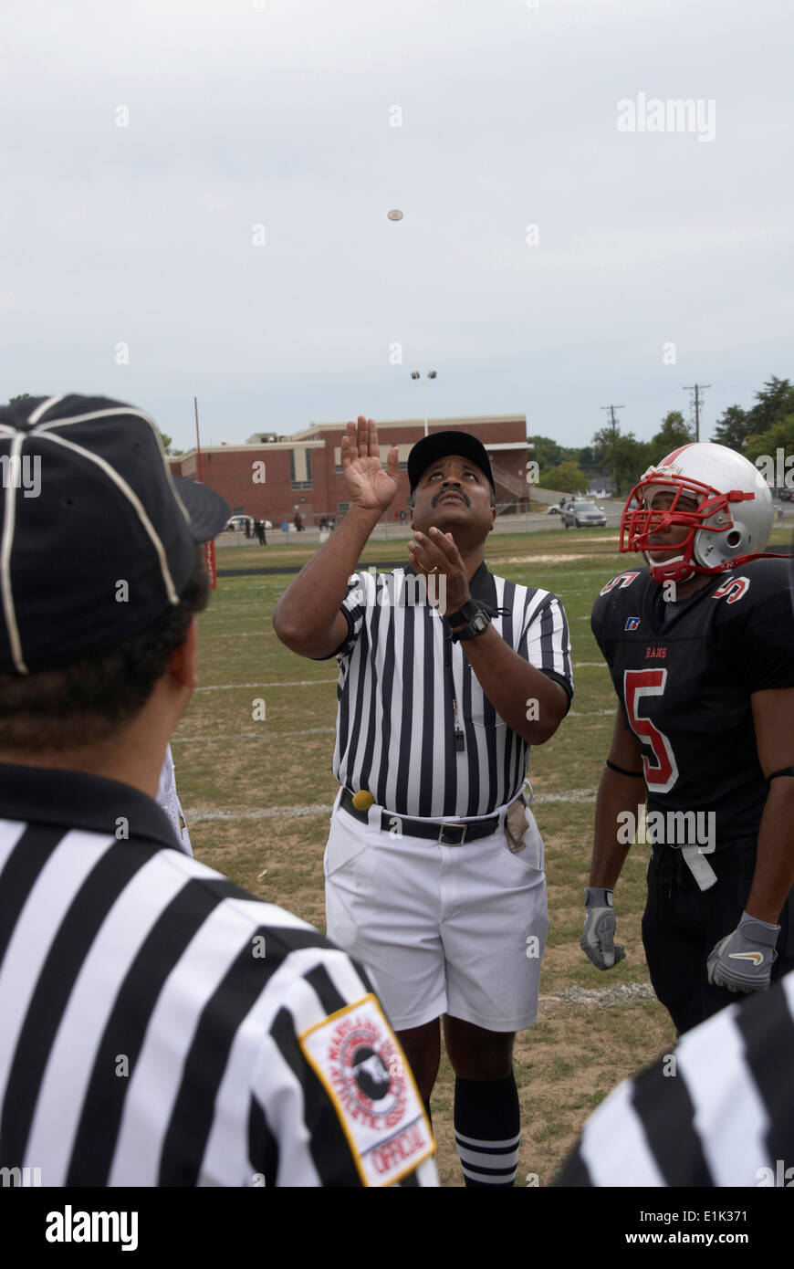 El árbitro lanza la moneda en el juego de fútbol americano a nivel high