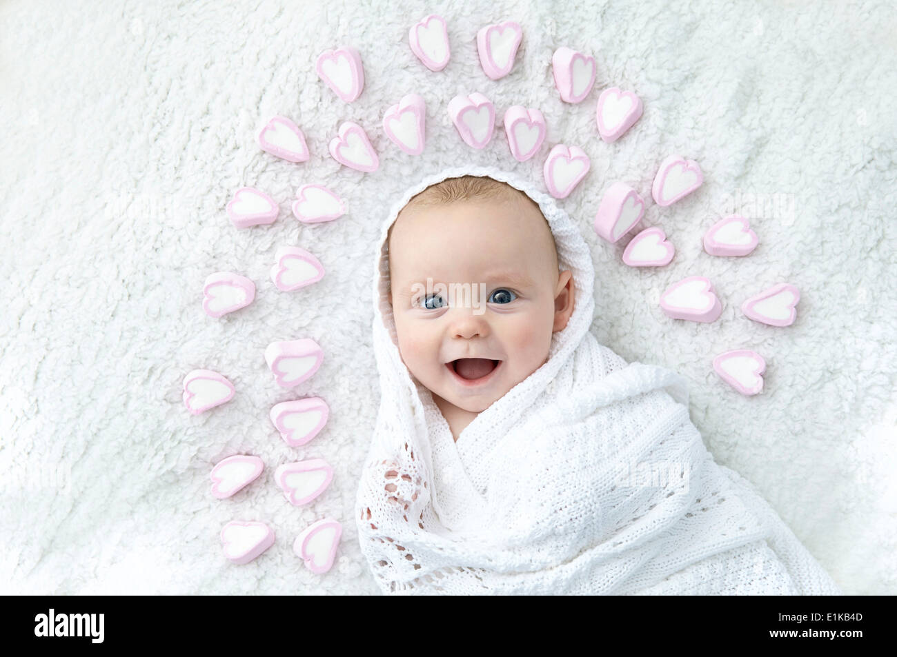 Publicado modelo Baby Boy envuelto en Manta, con formas de corazón alrededor de su cabeza. Foto de stock