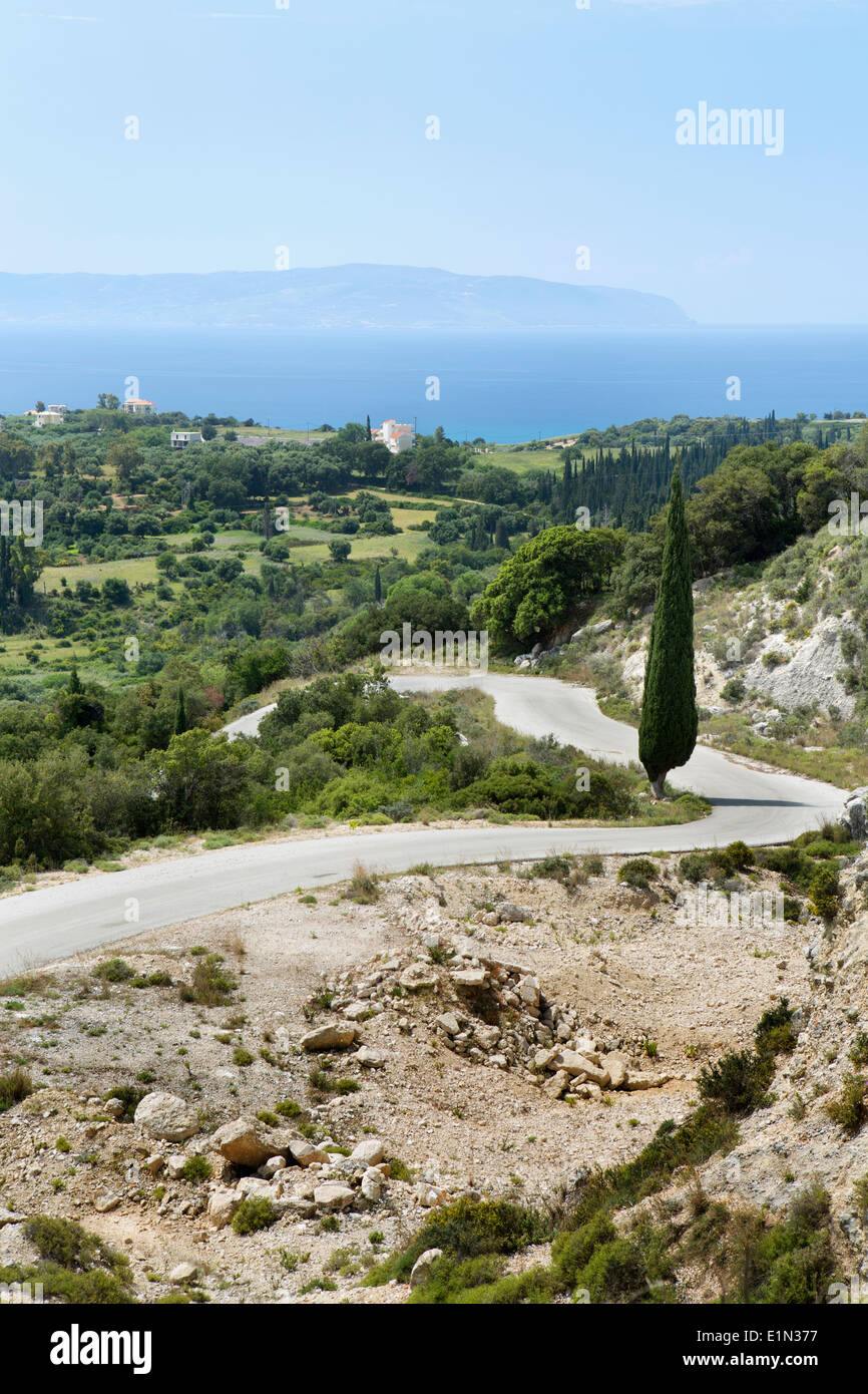 Un sinuoso camino se dobla alrededor de la ladera entre Skala y antiguo Skala en Kefalonia con vistas al mar a Zanti, Grecia Foto de stock