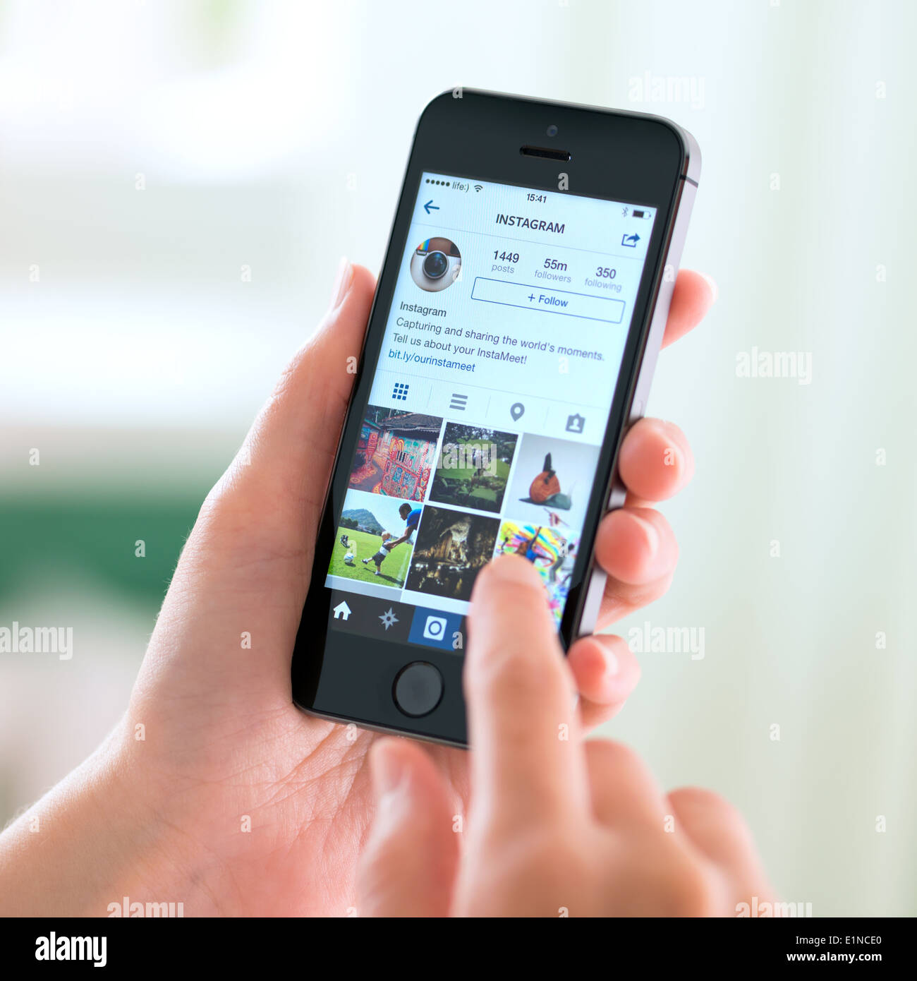 Persona sosteniendo un nuevo Apple iPhone 5S con Instagram perfil en la pantalla. Foto de stock