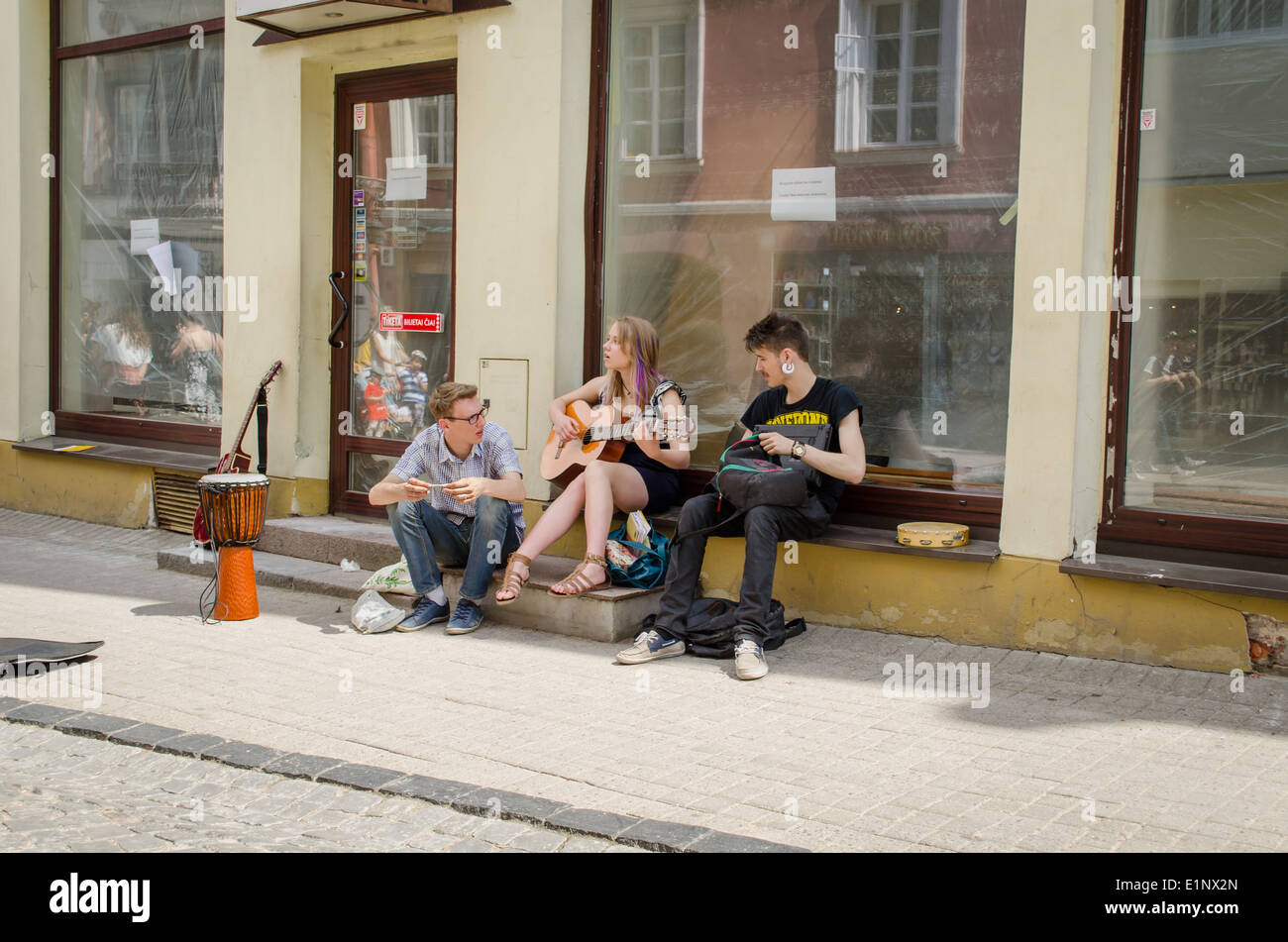Los jóvenes músicos callejeros cantando reproduce instrumentos Foto de stock