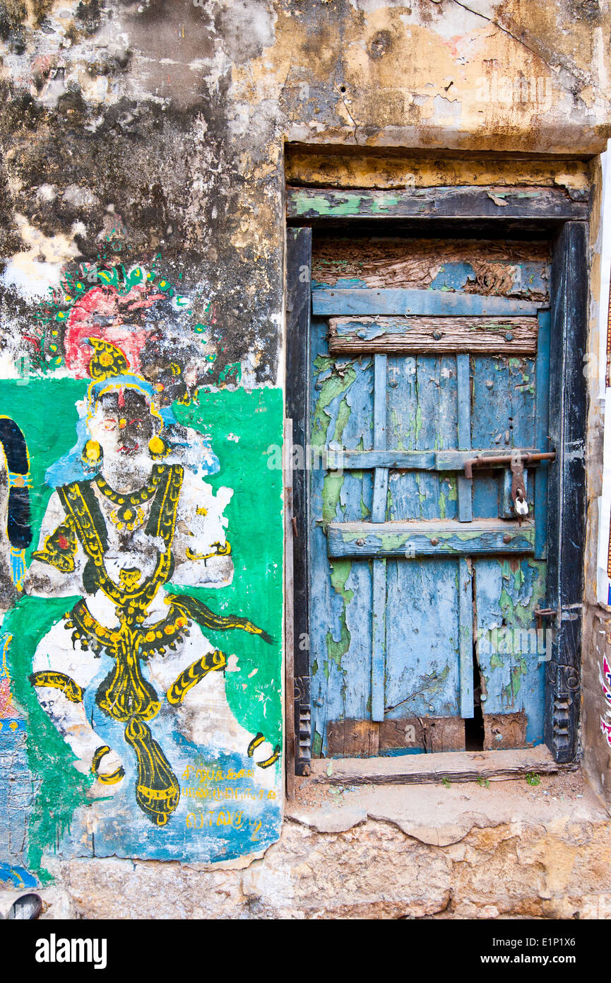 Colores brillantes Indian street composición colorida vida antigua puerta azul y agrietada pintura religiosa sobre la pared grunge en el sur de la India Foto de stock