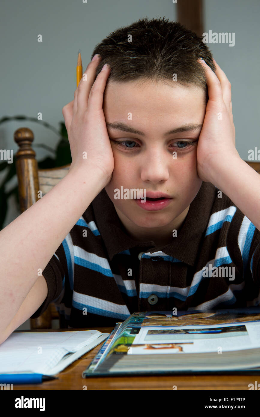 Un joven adolescente estresado durante la tarea. Foto de stock