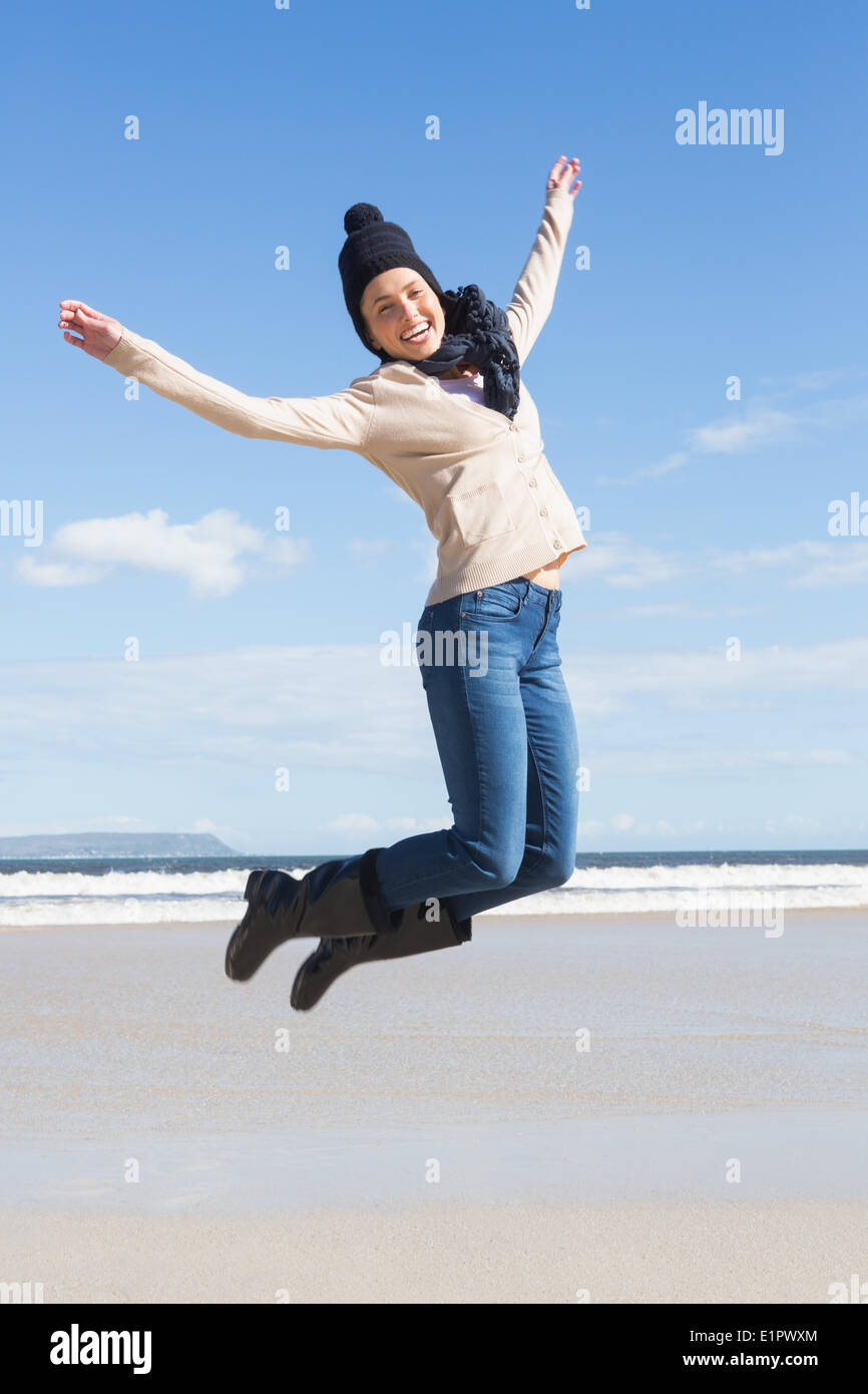 Bonita rubia en jeans saltando en la playa Foto de stock