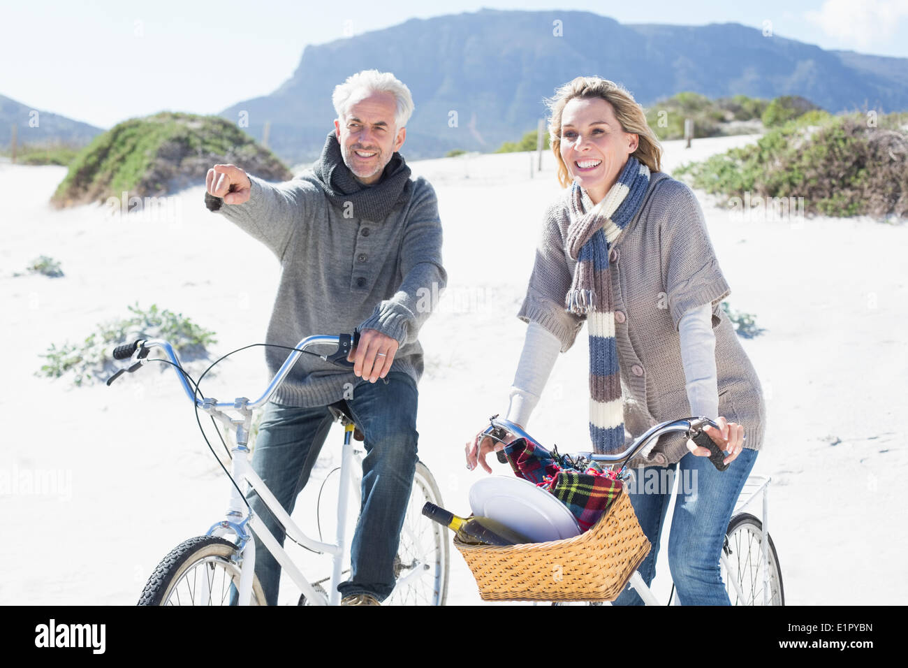 Pareja despreocupada de ir en bicicleta y hacer un picnic en la playa Foto de stock