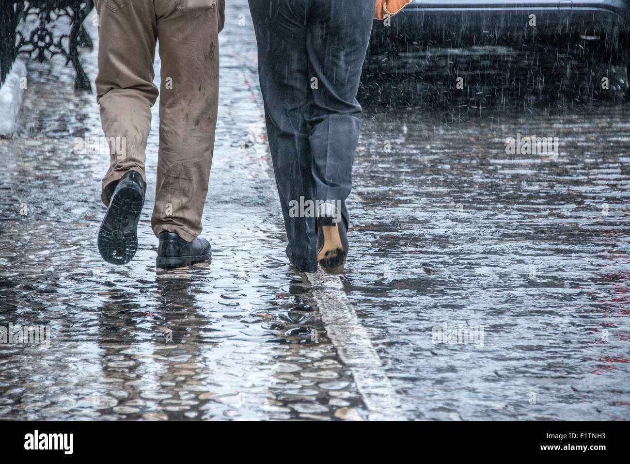 Hombre caminando bajo la lluvia fotografías e imágenes de alta