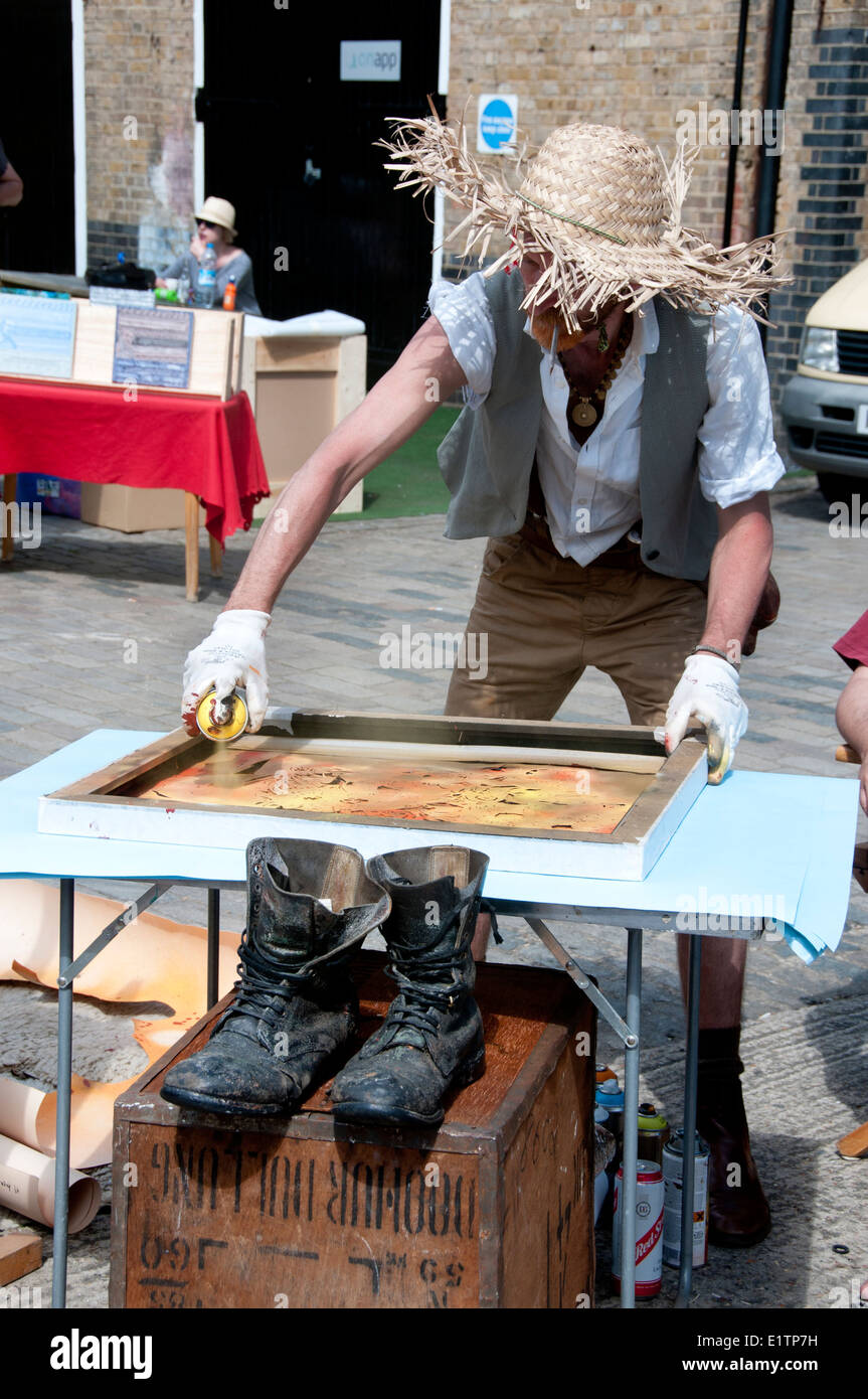 Vauxhall Car Boot Art Fair. Un artista vestido como Van Gogh produce girasoles para el día moderno - uso de aerosoles y galería Foto de stock