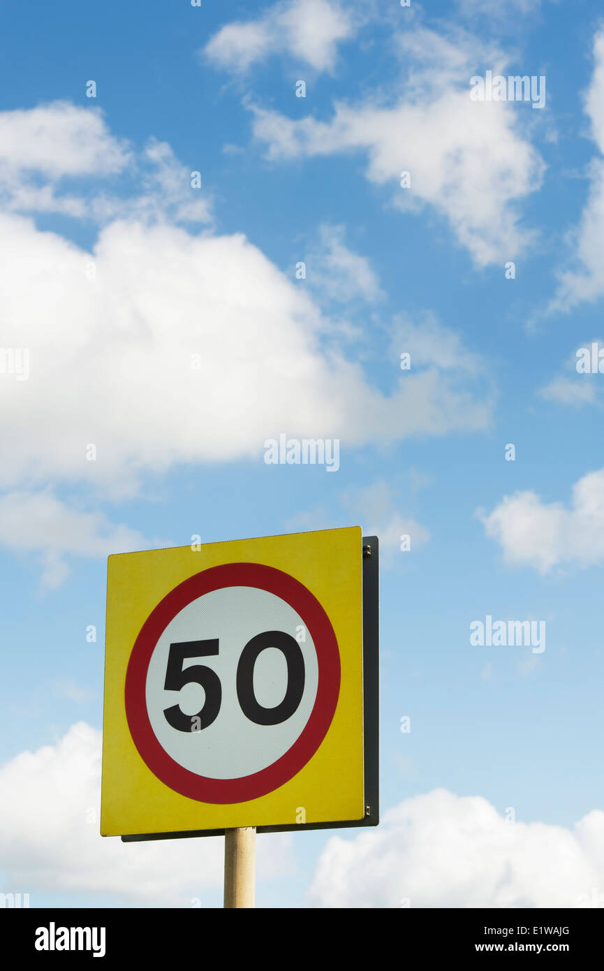 Límite de velocidad de 50 MPH cartel contra el azul cielo nublado. Inglaterra Foto de stock