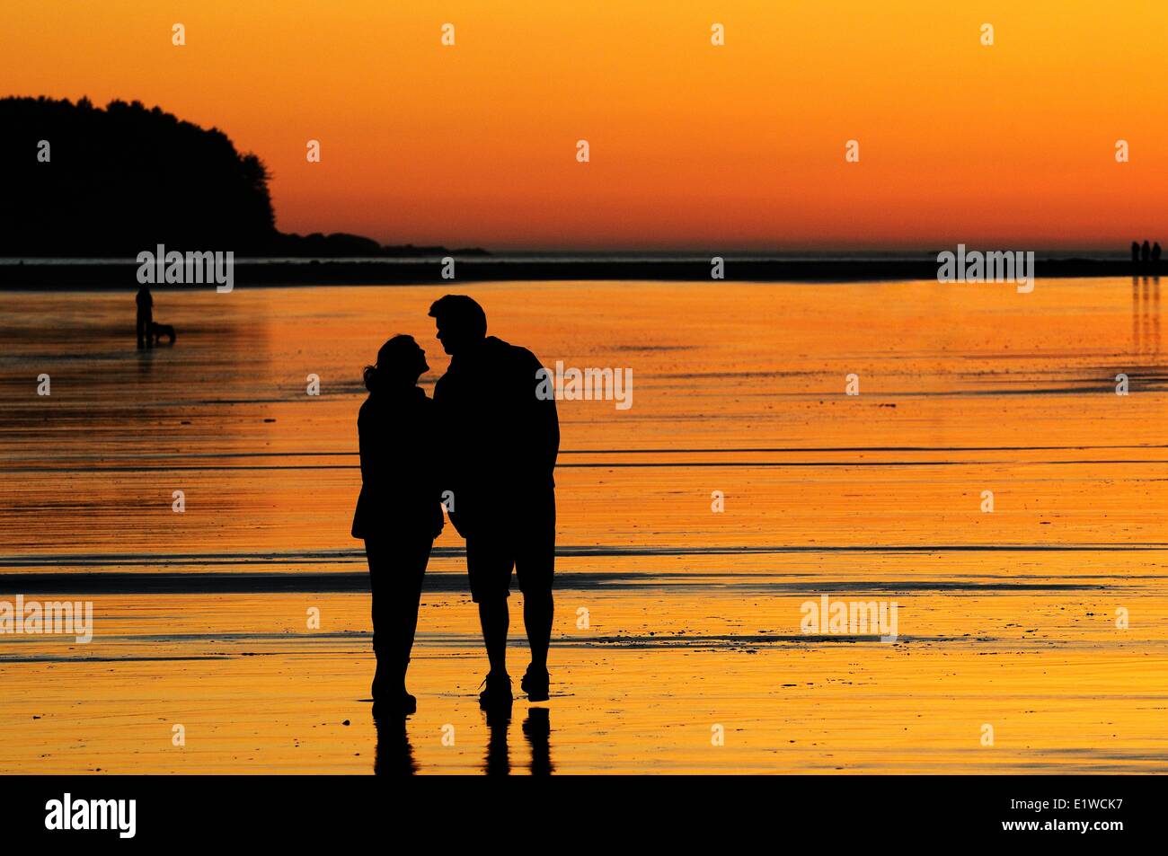 Una joven pareja al atardecer a punto de kiss mientras Chesterman Beach cerca de Tofino, BC. Foto de stock