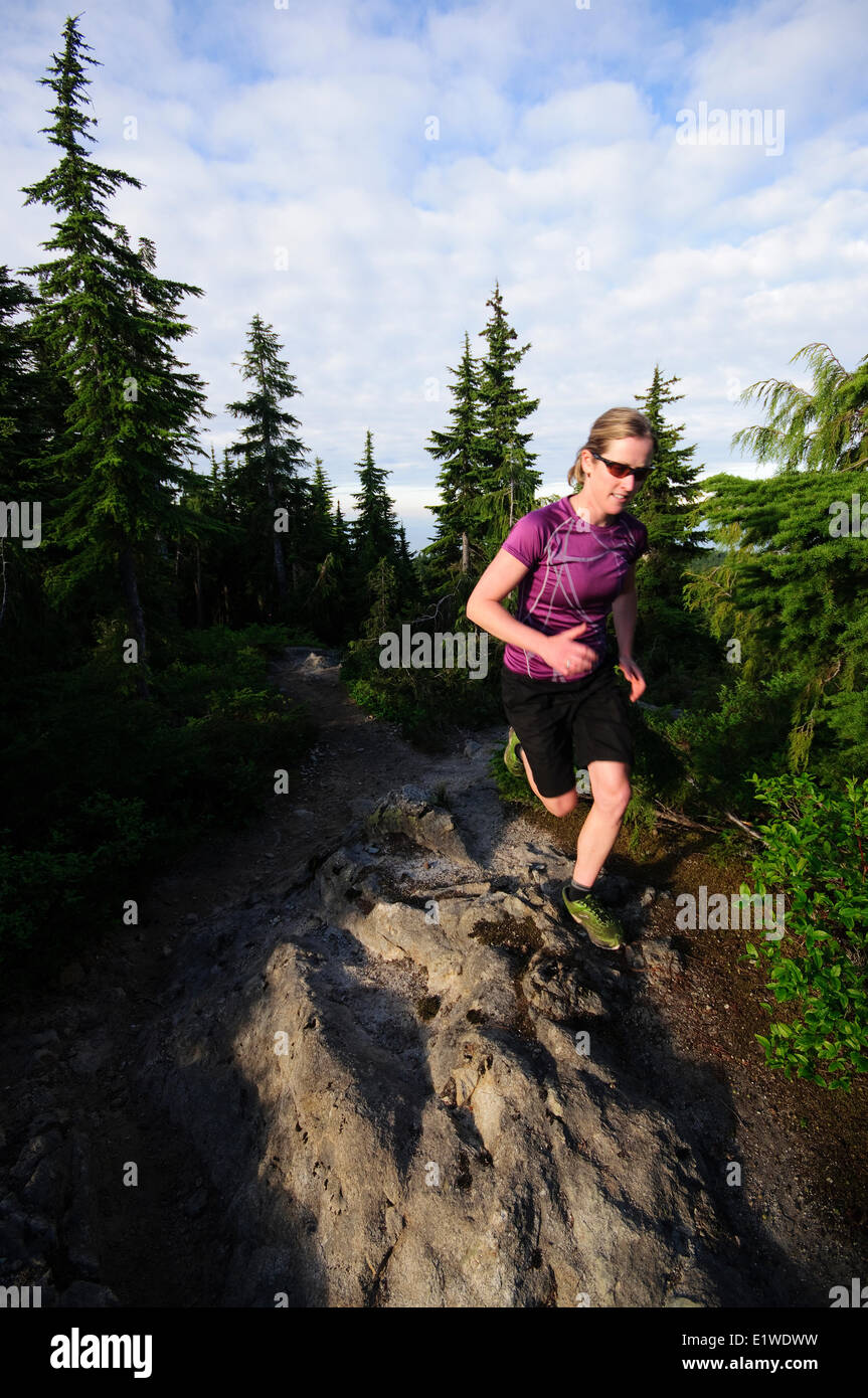 Trail running femenino en la cabina Lake Trail en la Montaña Negra. Cipreses Parque Provincial. West Vancouver, British Columbia, Canadá Foto de stock