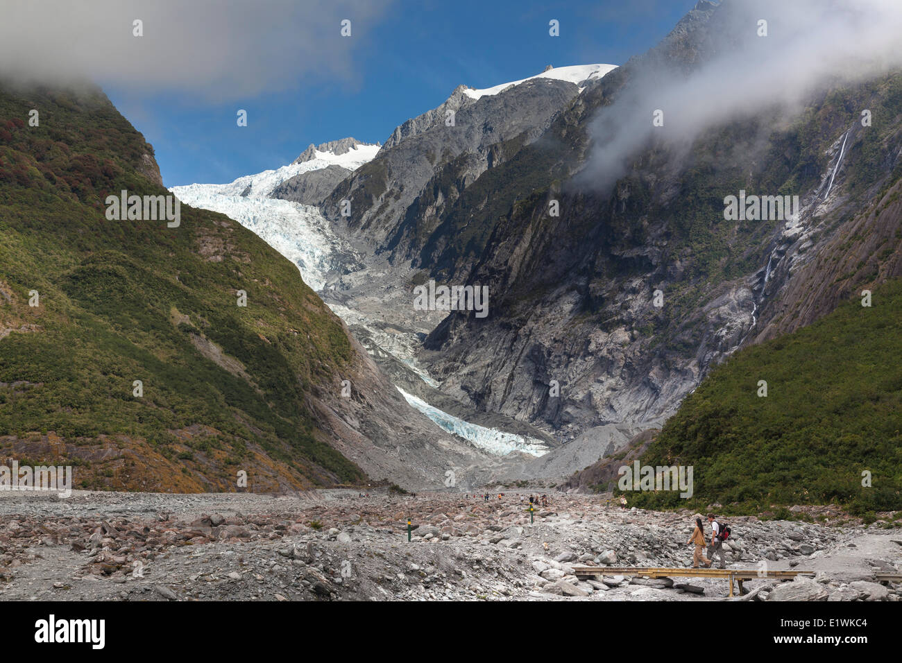 Las personas trekking hacia el glaciar Franz Josef en Westland Tai Poutini National Park en la costa oeste de la Isla Sur de Nueva celo Foto de stock
