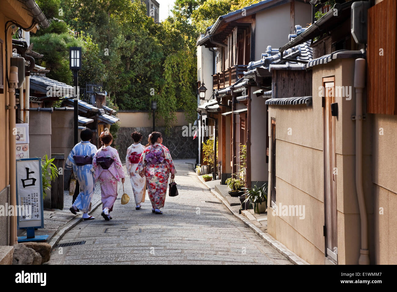 Cuatro mujeres japonesas paseando por un callejón, vistiendo yukatas, Distrito Higashiyama de Kyoto, Japón Foto de stock