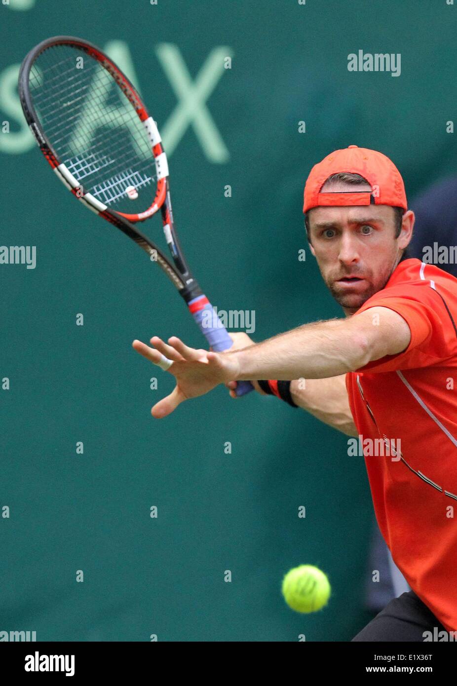 Tenista alemán Benjamin Becker en acción durante la primera vuelta del partido contra el tenista francés Monfils en el torneo ATP de Halle (Westfalia), Alemania, el 10 de junio de 2014. Foto: OLIVER KRATO/dpa Foto de stock