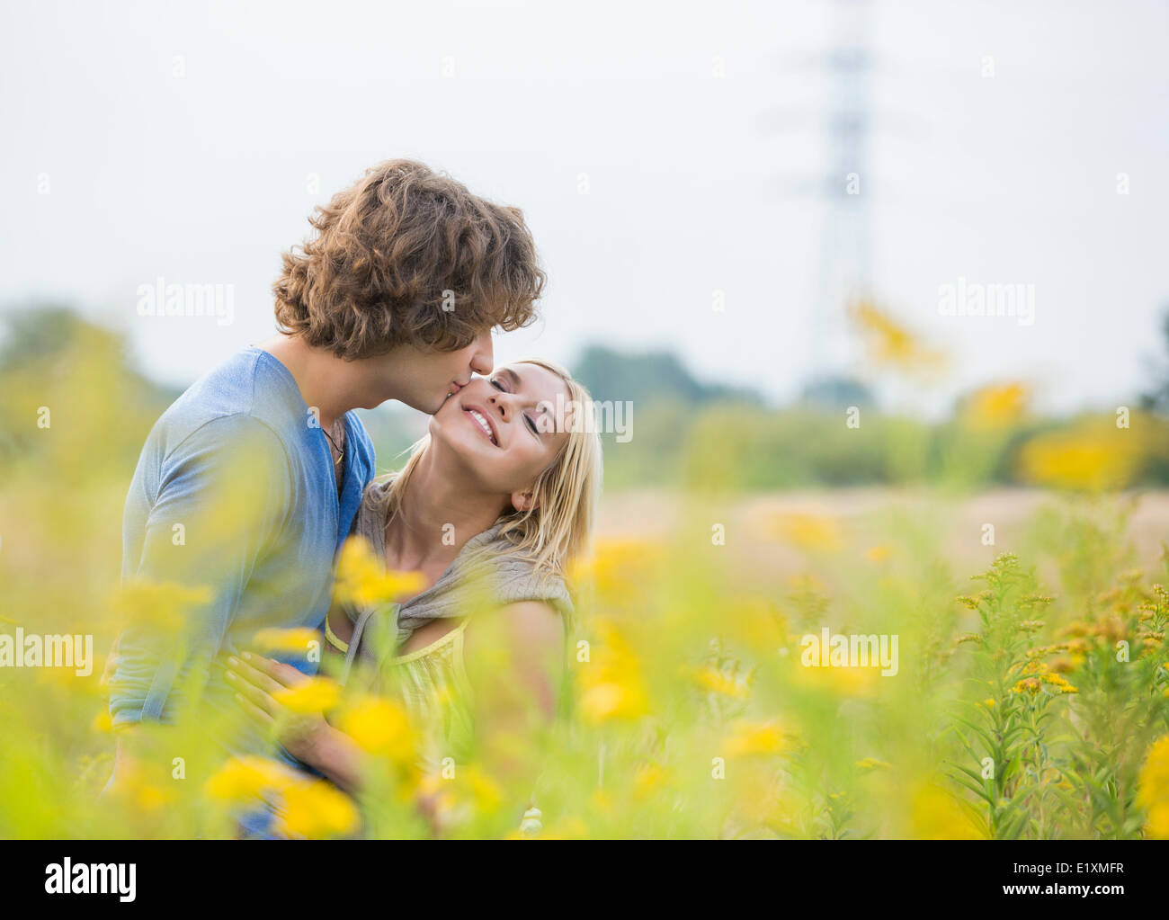 El hombre romántico besar a la mujer en el campo Foto de stock