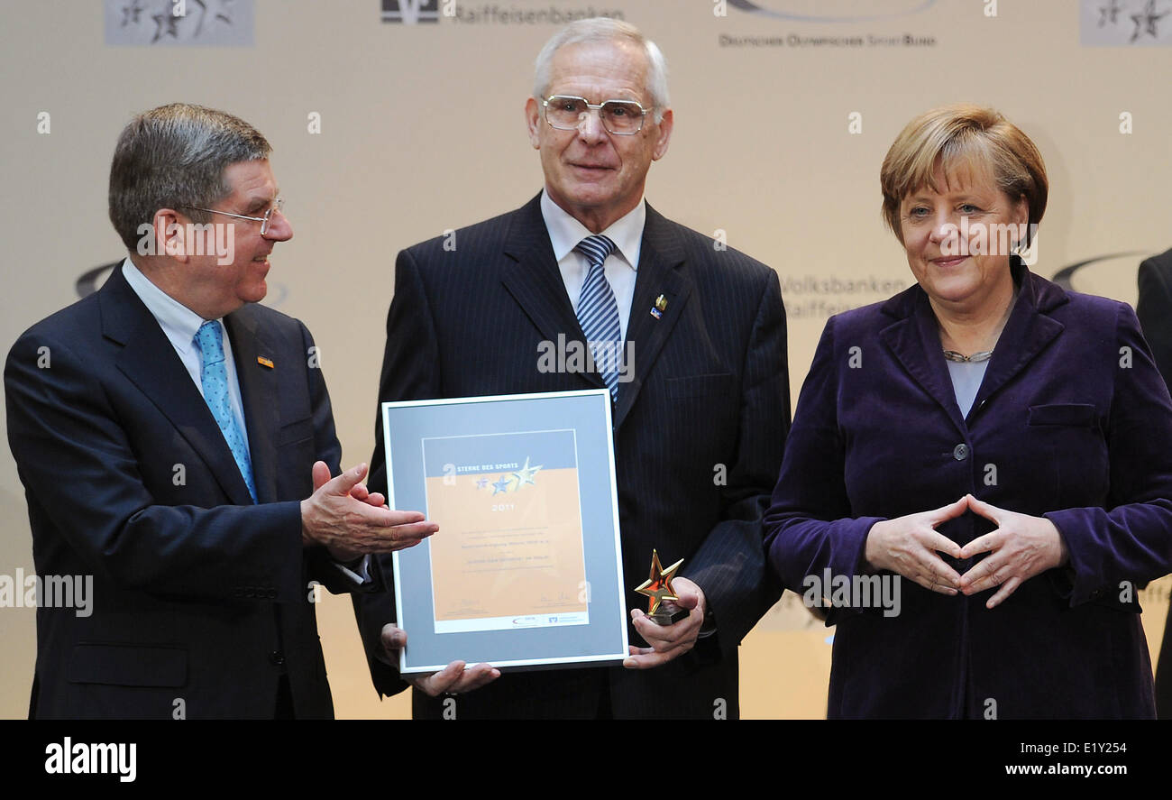 La canciller alemana, Angela Merkel, y el presidente de la Confederación Alemana de Deportes Olímpicos Thomas Bach (l) el premio 'estrella de los deportes" de Klaus Leonhardt (M) el 7 de febrero de 2012. Foto de stock
