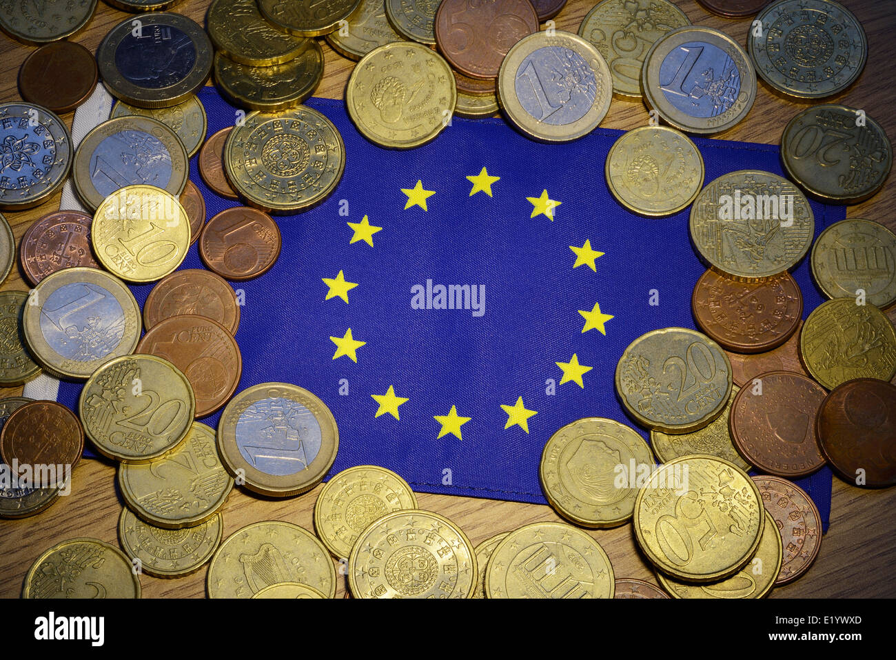 Las monedas de euro y una bandera de la UE Foto de stock