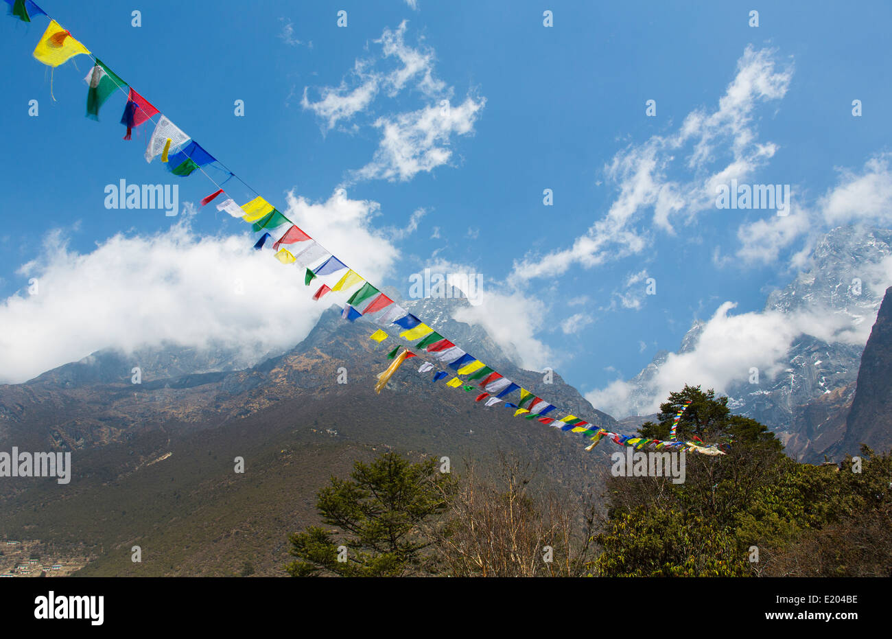 Nepal banderas de oración ondeando en el viento con el Himalaya detrás de ellos Solukhumbu. Foto de stock