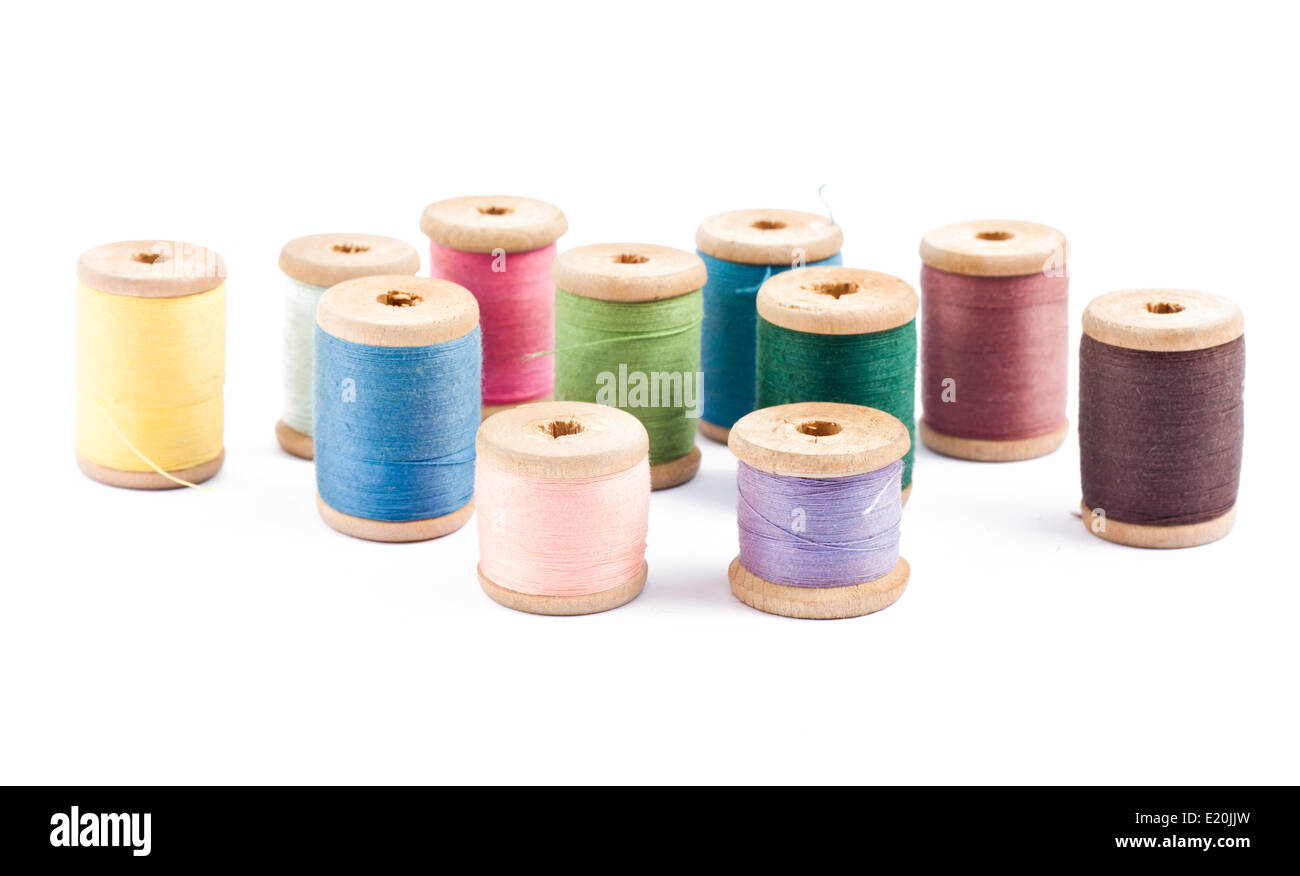 Las bobinas de hilo multicolor de madera en blanco Foto de stock