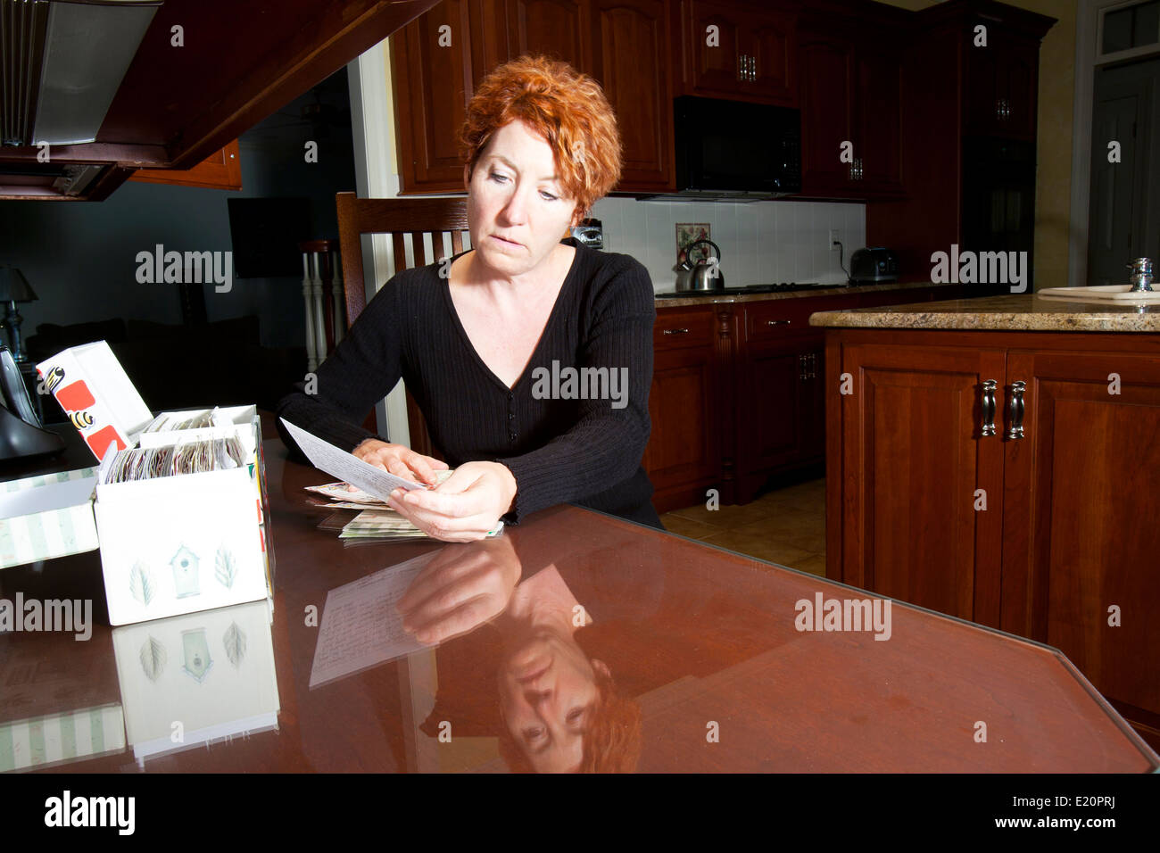 Clasificación femenina recetas en una mesa de cocina Foto de stock