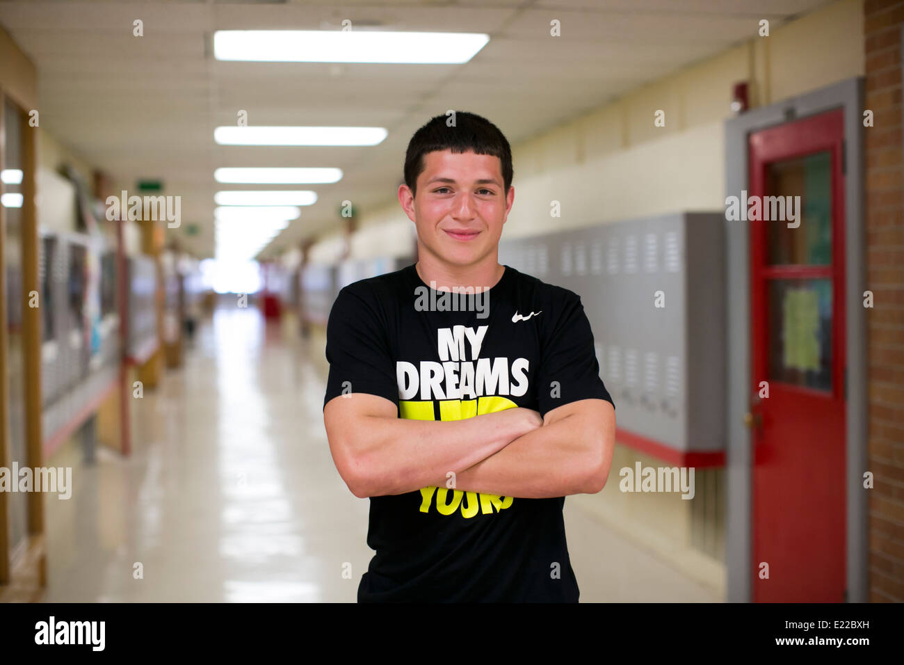 Estudiante de secundaria masculina atleta, plantea en el pasillo de su escuela, Austin, Texas Foto de stock