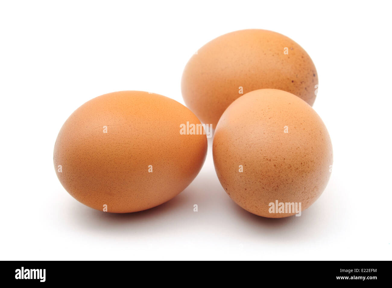 Tres huevos de gallina sobre fondo blanco. Foto de stock
