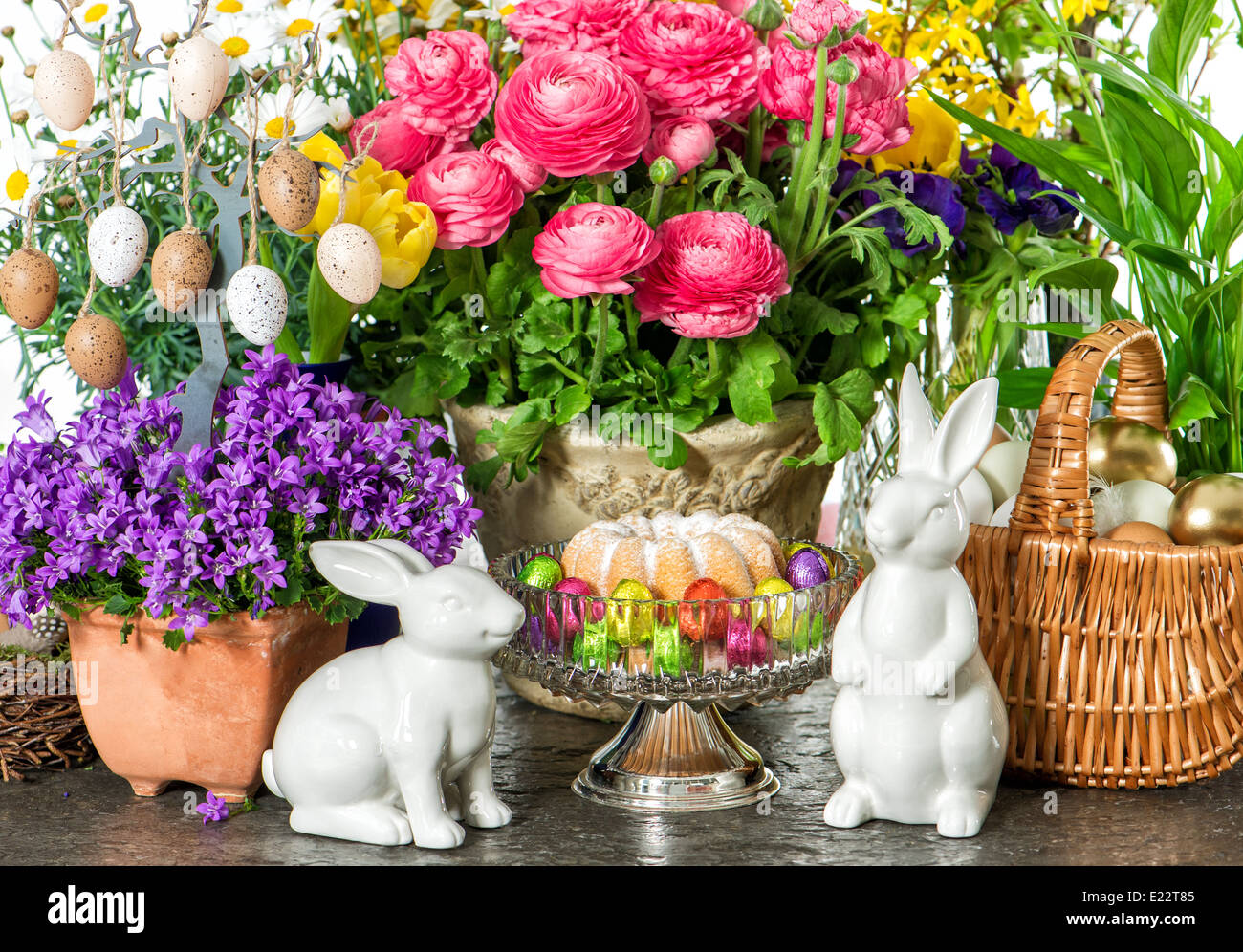 Decoración de pascua con pastel, las flores de la primavera, los huevos y los conejitos Foto de stock